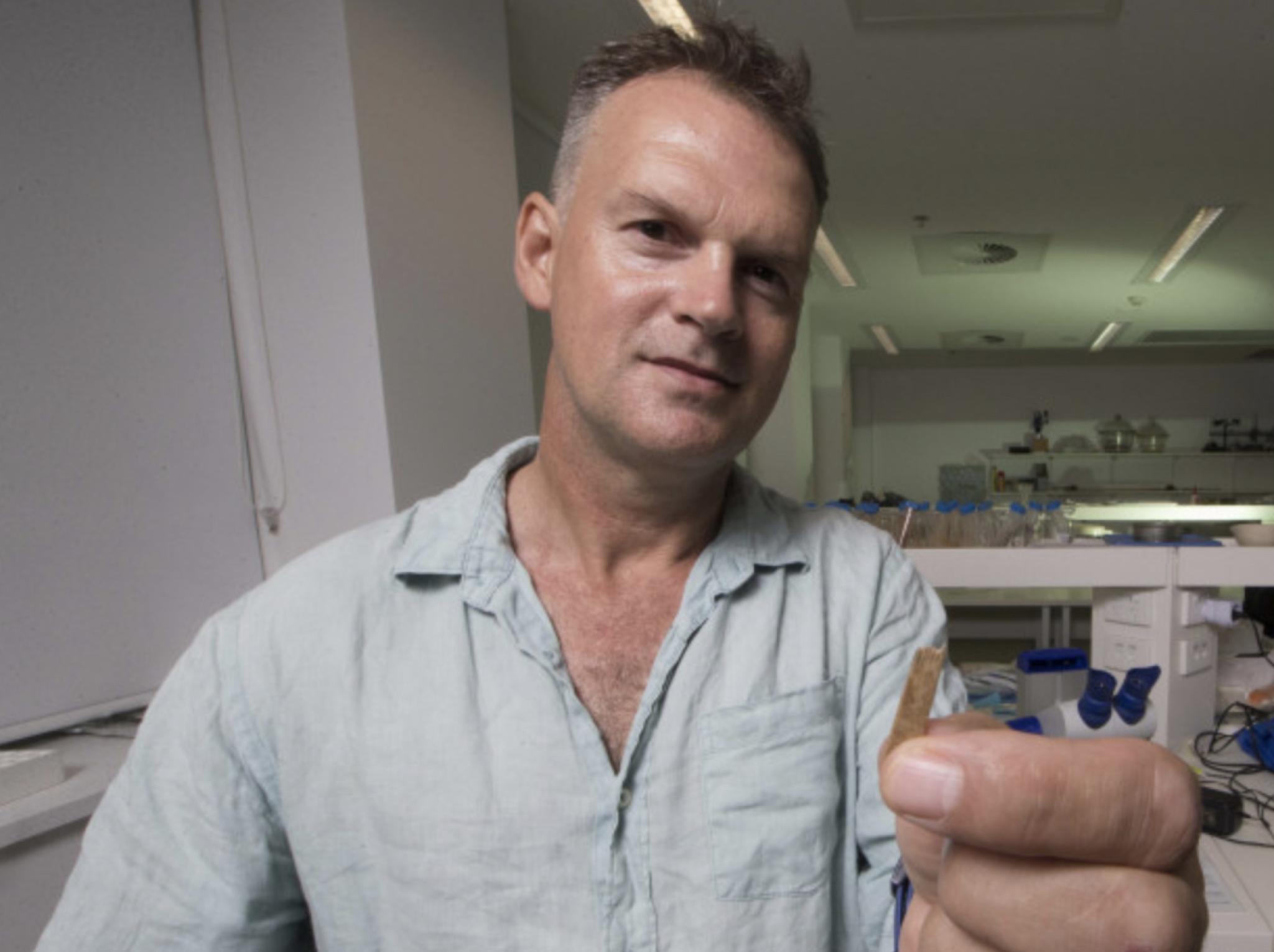 A midshot of Geoffrey Clark facing the camera in a lab