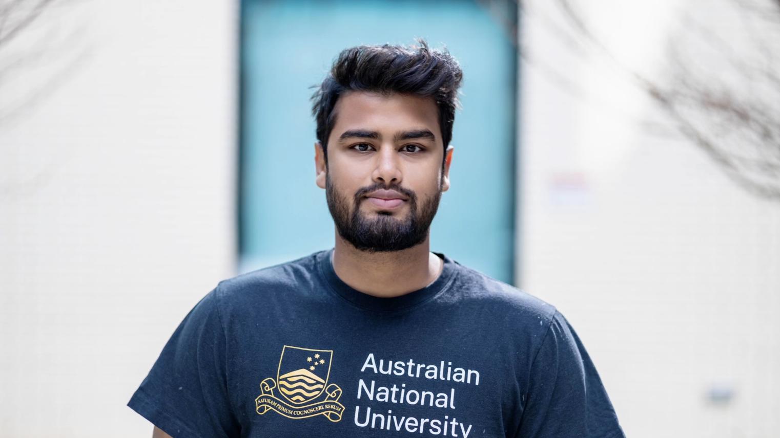 Student Sai Hossain looking at camera wearing an ANU shirt